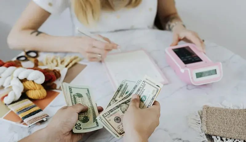 Two people counting money for primary savings